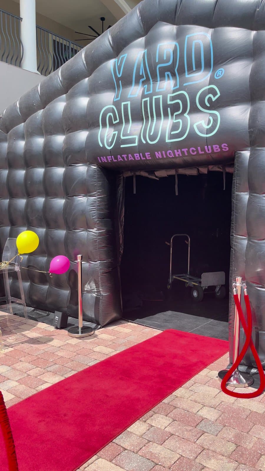A Yard Clubs nightclub at a home with balloons and a red carpet at the door