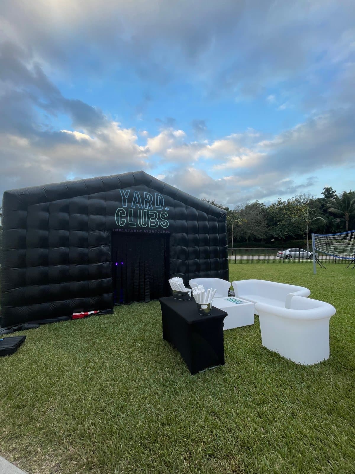 A Yard Clubs nightclub with a white lounge set on the lawn under a cloudy sky