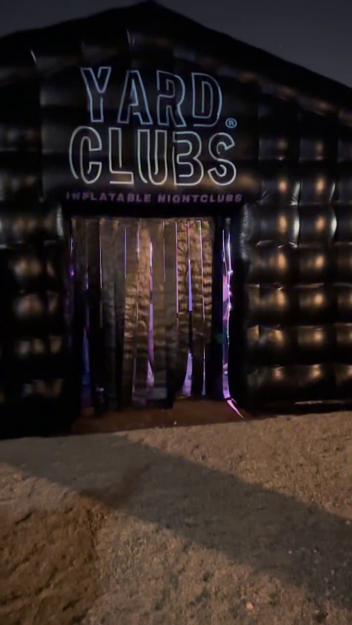 The Yard Clubs sign lit over the curtain door at night