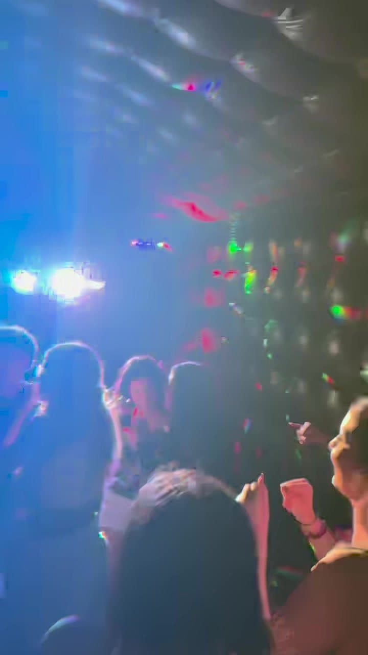 Guests dancing under the club's tufted ceiling and party lights