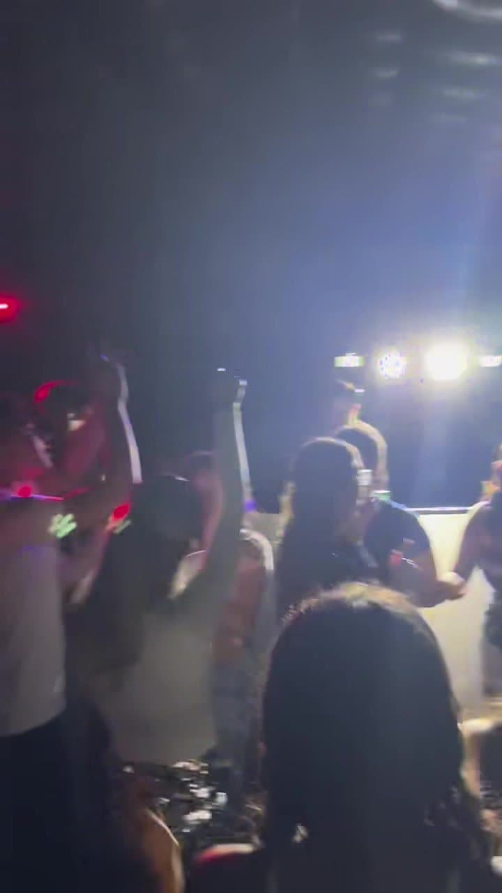 Hands up under the DJ lights inside the club
