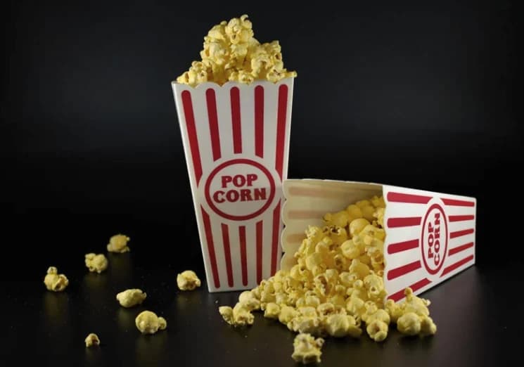 Popcorn spilling out of red-and-white striped popcorn boxes